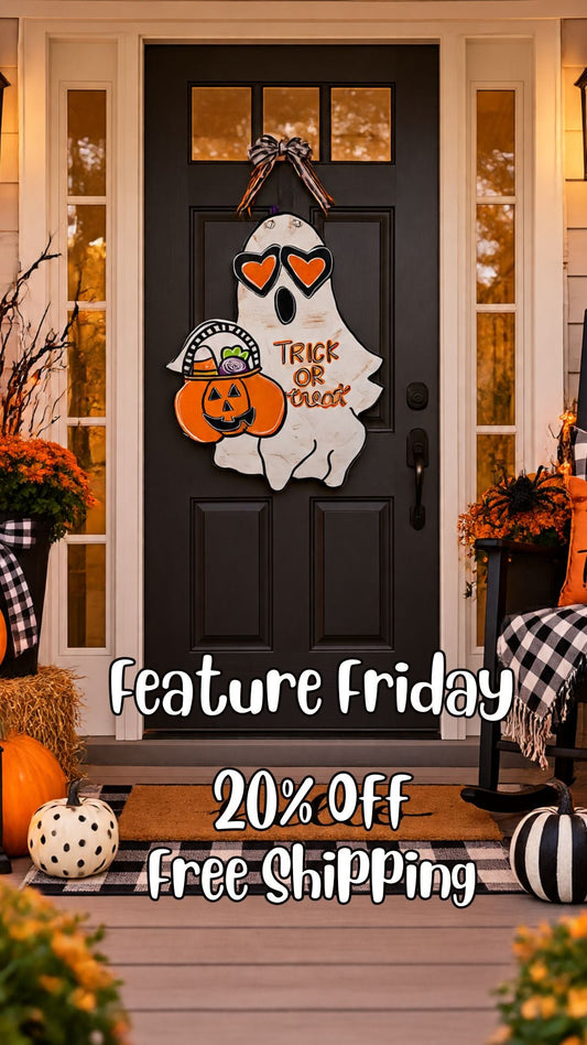 Hand-painted Trick or Treat Ghost door hanger styled on a fall front porch with mums, pumpkins and a buffalo-check rug